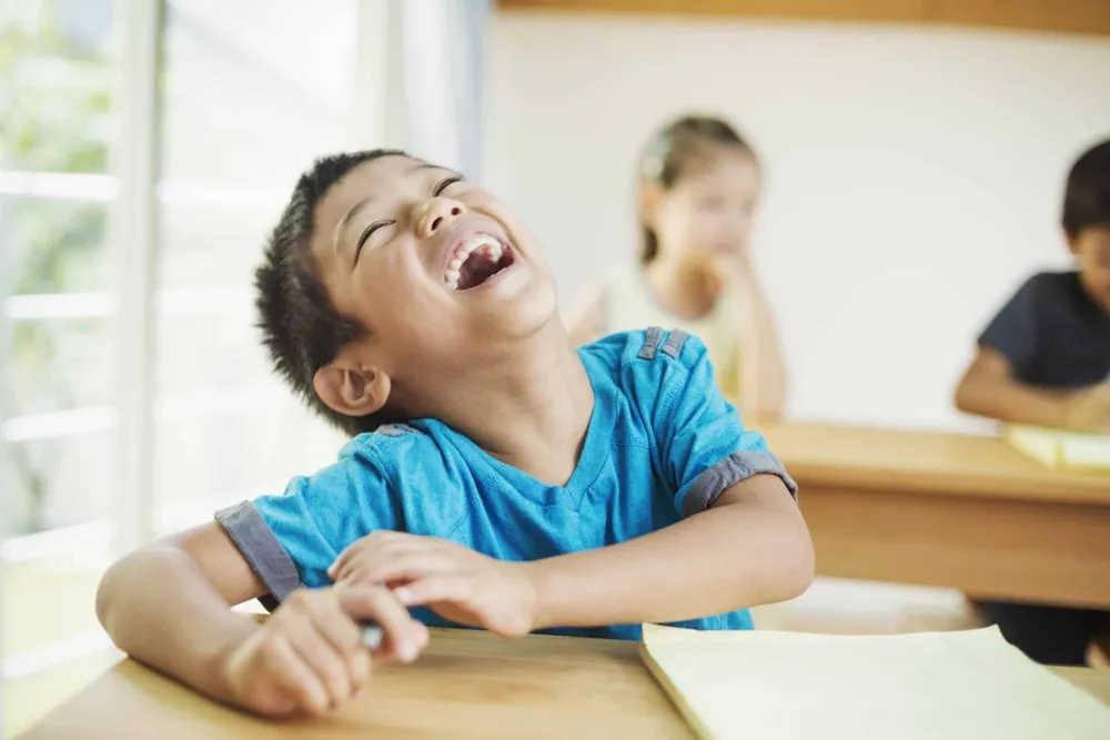 Happy child during classroom activity representing well-child examinations and pediatric care in Whitby