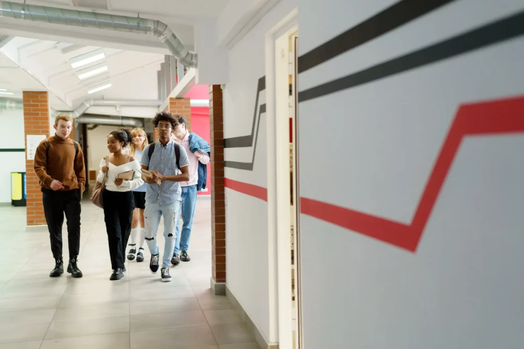 Group of teenagers walking in school hallway representing adolescent or young adult health consultations