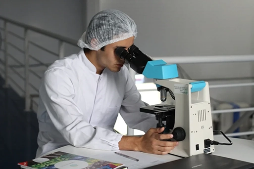 Medical researcher using a microscope in laboratory for health diagnostics and scientific testing